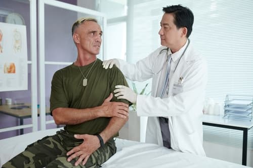 A veteran consulting with a doctor about veteran pain treatments at VeriSpine Joint Centers.